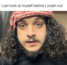 a man with curly hair and a beard is wearing a red and white scarf and a black shirt