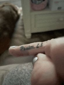 a close up of a person 's finger with a tattoo of psalm 23