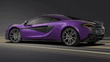 a purple mclaren car is driving down the road