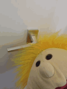 a stuffed animal with yellow hair and a silver handle