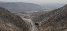 an aerial view of a road in the middle of a mountain valley .