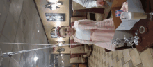 a little girl wearing a birthday hat stands in a restaurant