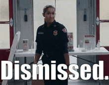 a woman in a firefighter uniform is standing in front of a table with the words dismissed written on it