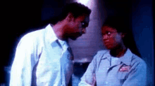 a man and a woman are standing next to each other in a dark room .