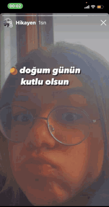 a woman wearing glasses is looking at the camera with a caption that says doğum gunun kutlu olsun