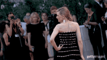 a woman in a black strapless dress is standing on a red carpet with gettyimages written on the bottom of the image