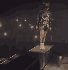 a woman is walking on a stage in a dark room .