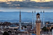 an aerial view of a city with a clock tower in the foreground and the website www.gezilesyer.com visible