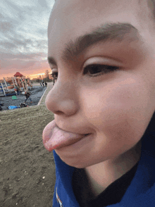 a close up of a child 's face with his tongue sticking out