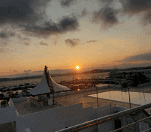 a sunset over a body of water with boats in the water