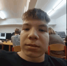 a young man is taking a picture of himself in a classroom .