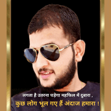 a man with a beard wearing ray-ban sunglasses stands in front of a black background