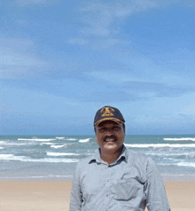 a man wearing a hat that says veteran is standing on a beach