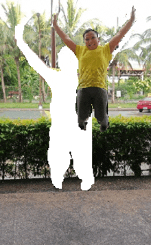 a woman in a yellow shirt jumps in the air