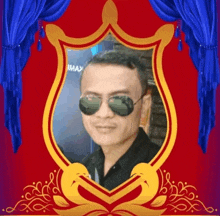 a man wearing sunglasses is in a gold frame with a blue curtain behind him