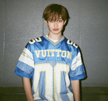 a young man wearing a blue and white louis vuitton football jersey