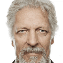 a man with gray hair and a beard has blue eyes