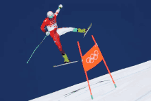 a skier wearing a red and white outfit with the number 21 on it is doing a trick