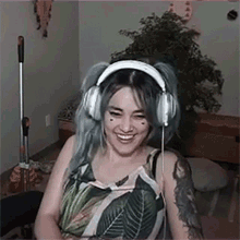 a woman wearing headphones is smiling while sitting in a living room .