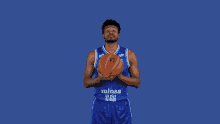 a man in a blue minas 10 jersey holds a basketball on his finger