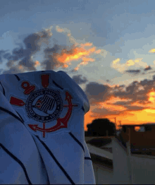 a corinthians paulista jersey is being held up in front of a sunset