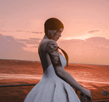 a woman in a wedding dress stands on a balcony overlooking the ocean at sunset