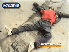 a man in a red shirt is laying on the ground in front of a kotelnews logo