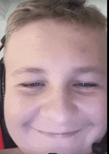 a close up of a boy 's face wearing headphones and smiling