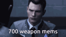 a man in a suit and tie is talking to another man with 700 weapon mems written below him