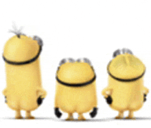 three yellow minions are standing next to each other .