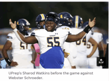 a football player with the number 55 on his jersey stands in front of his teammates