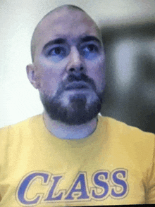 a man with a beard wears a yellow shirt with the word class on it