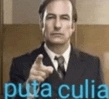 a man in a suit and tie is pointing at the camera with the words puta culia .