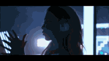 a silhouette of a woman in a dark room with a hand reaching out