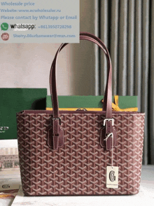 a goyard tote bag sits on a table next to a website