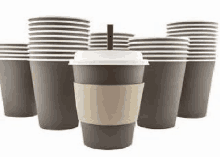 a group of paper coffee cups stacked on top of each other with a straw .