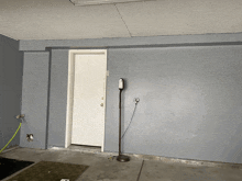 an empty garage with a door and a lamp on the floor