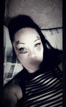 a woman with savage tattoo on her face