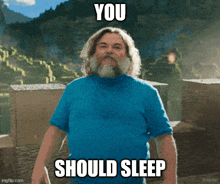 a man with a beard wearing a blue shirt has the words you should sleep above his head