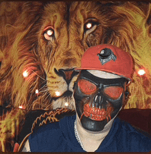 a man wearing a skull mask and a red hat with a lion in the background