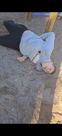 a person laying on the ground wearing a champion sweatshirt