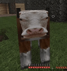 a cow made out of blocks is standing in the grass in a minecraft game .