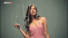 a woman in a pink dress is standing in front of a wall covered in duct tape .