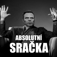 a man in a suit and tie is sitting in a chair with his hands in the air and the words absolutni sracka above him