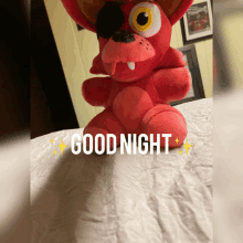 a red stuffed animal with the words good night written on the bottom