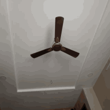 a ceiling fan with three blades is hanging from a white ceiling