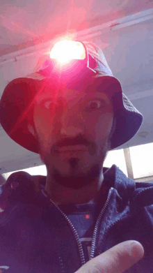 a man wearing a bucket hat with a red light on it