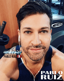 pablo ruiz is wearing ear buds and smiling in front of a le parc machine