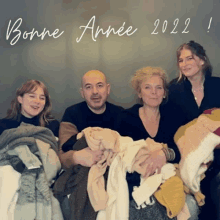 a family posing for a picture with a bonne année 2022 greeting