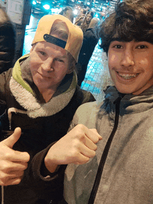 two young men are posing for a picture and one is wearing braces